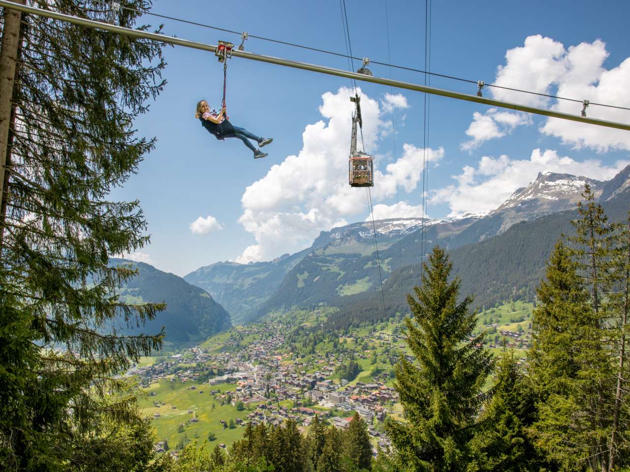 Pfingstegg Fly Line with one person. Grindelwald and gondola lift in the background.