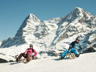 Schlitten in Mürren mit der Aussicht auf das Dreigestirn, Eiger, Mönch und Jungfrau.