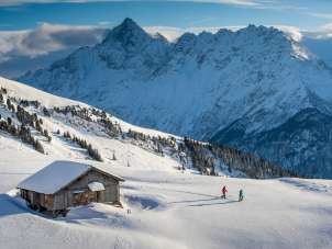 Vor eindrücklicher Bergkulisse: Zwei Schneeschuhläufer*innen unterwegs am Hasliberg
