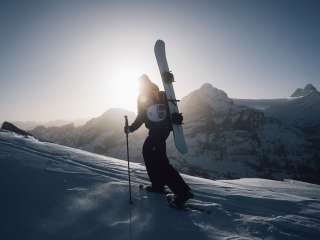 Snowshoeing on the First with a snowboard on my back in the morning sun.