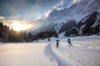 Bei Sonnenuntergang: Zwei Langläufer*innen unterwegs auf der Loipe in Guttannen.