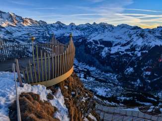 Die Krone vom Royal Walk wird von der untergehenden Sonne beleuchet. Das verschneite Bergpanorama im Hintergrund verleiht der Region rund um Wengen eine magische Stimmung.