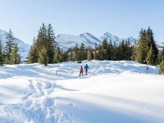 Unterwegs in der verschneiten Landschaft bei sonnigem Wetter mit den Schneeschuhen. Der Schneeschuhtrail in Mürren bietet eine einmalige Sicht auf das Gspaltenhorn.
