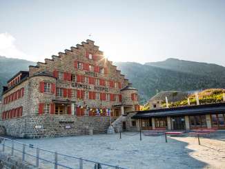Die Sonne scheint hinter dem Grimsel Hospiz Hotel hervor.