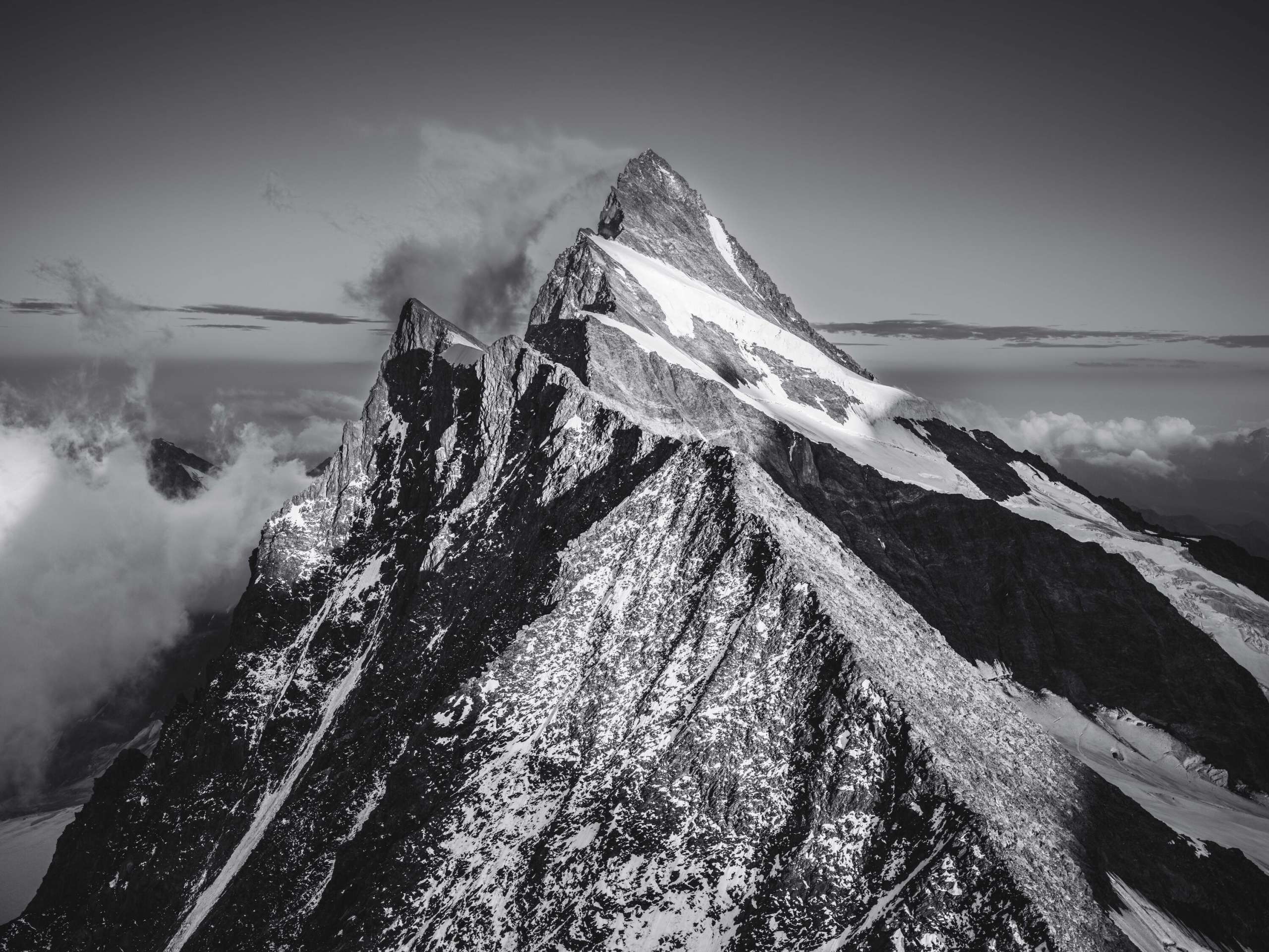 Finsteraarhorn Photo noir et blanc du Finsteraarhorn par l'arête avec un panorama de montagne.